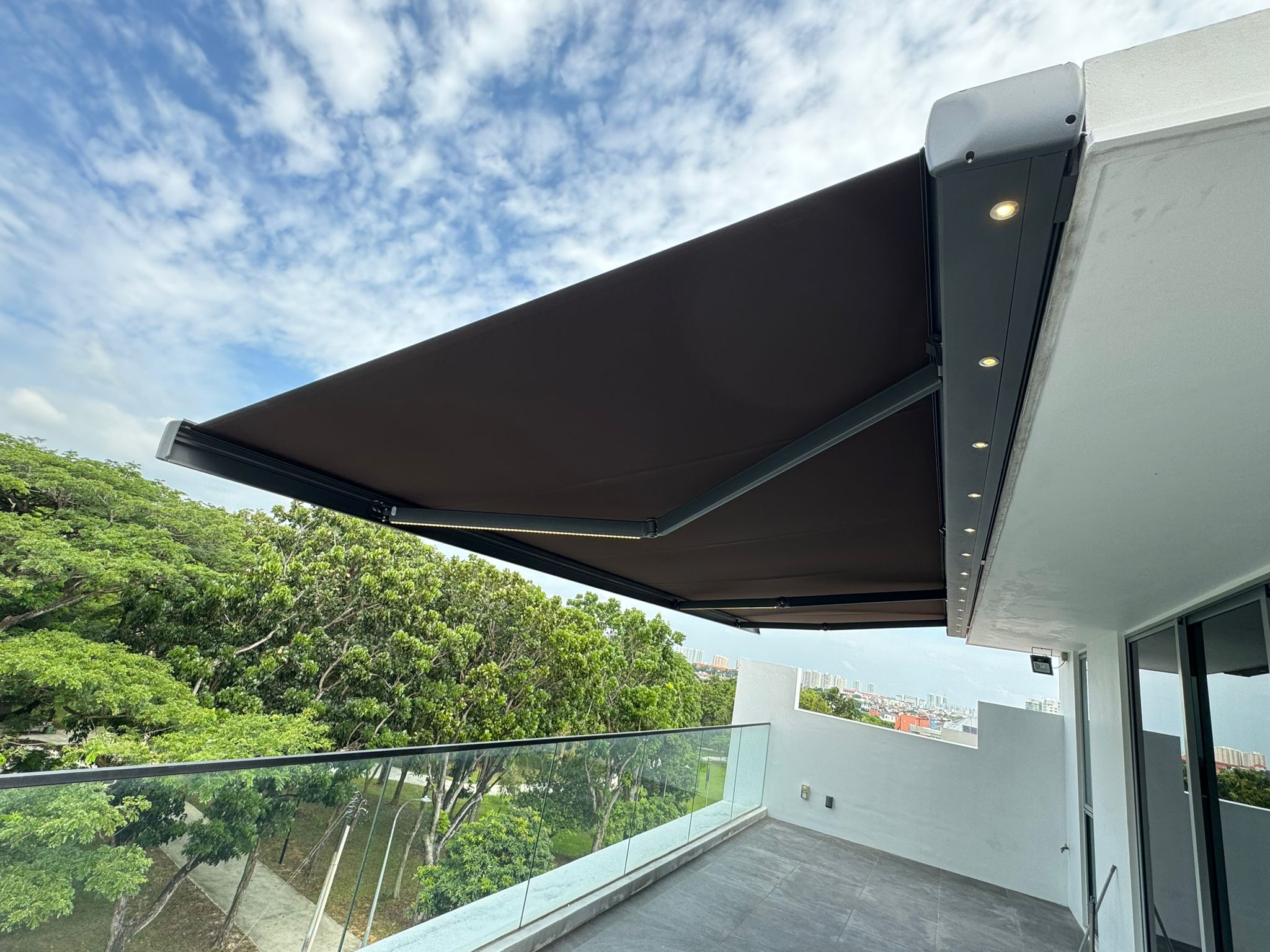 Retractable awning protecting an exposed upper-floor balcony