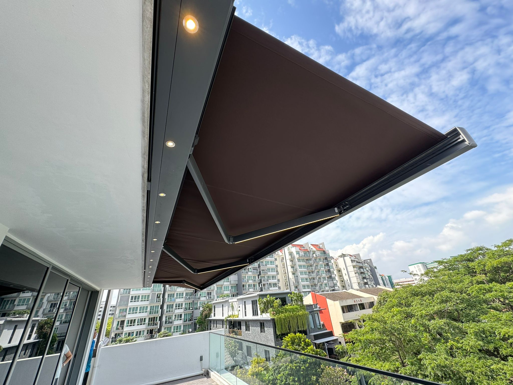 Motorised awning extended over an upper-floor residential balcony