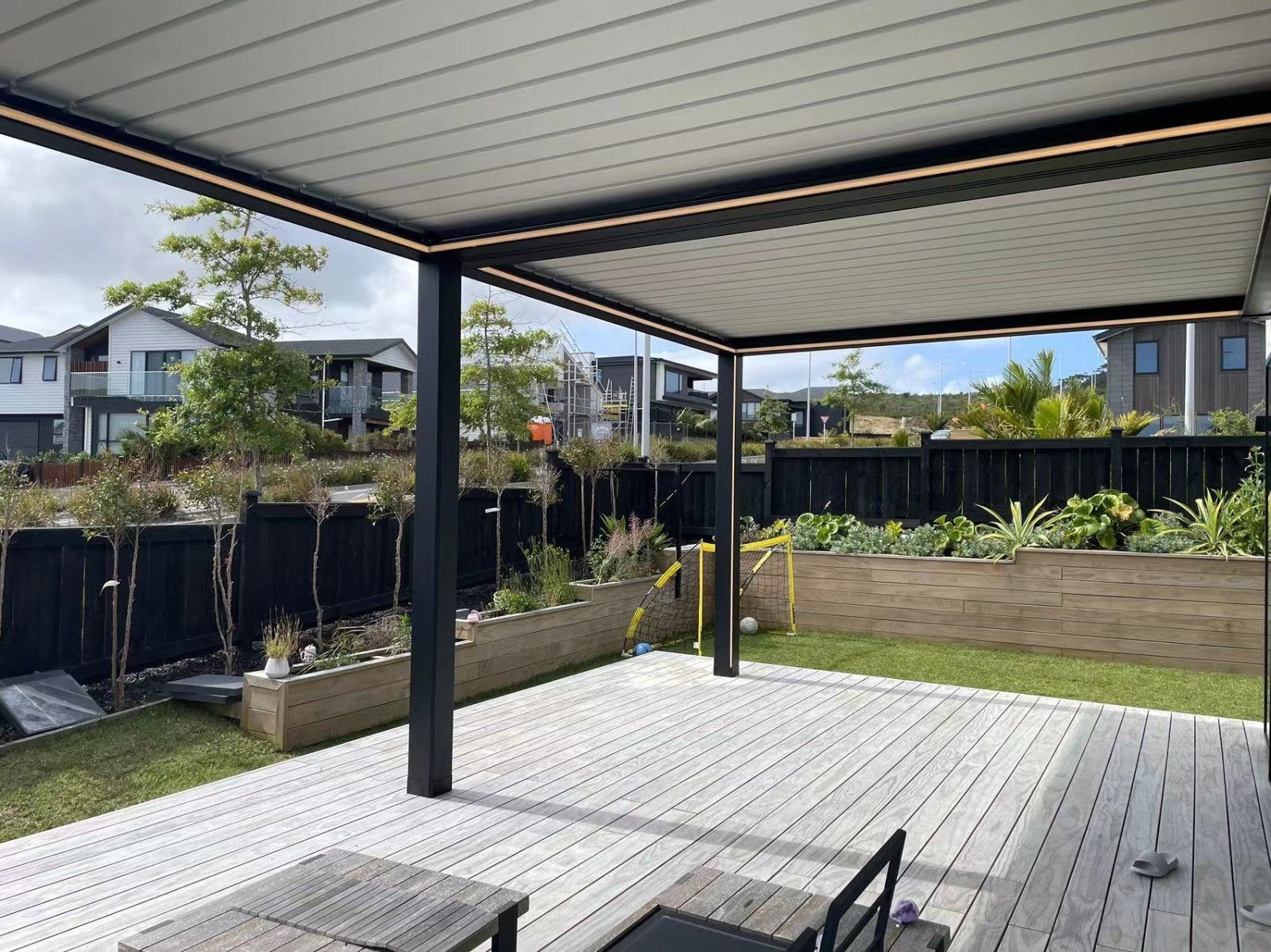 Aluminium patio pergola creating shade over an open garden terrace