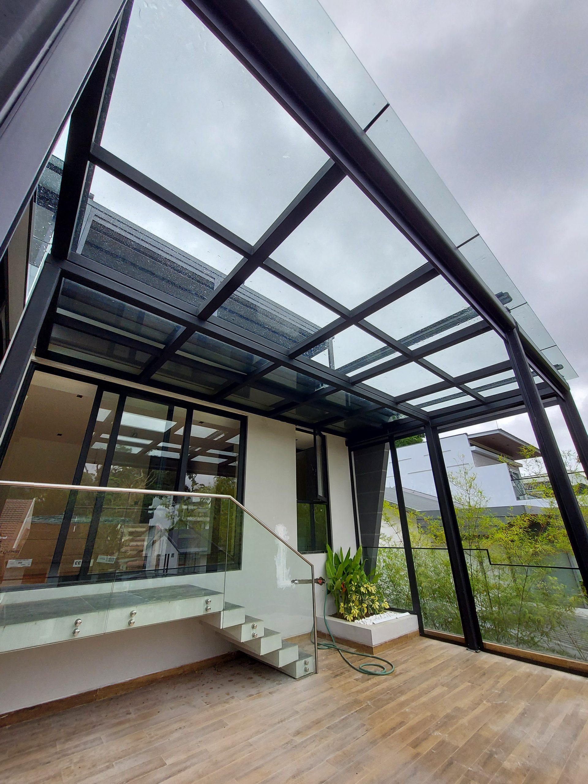 Laminated glass canopy preserving daylight above an outdoor area