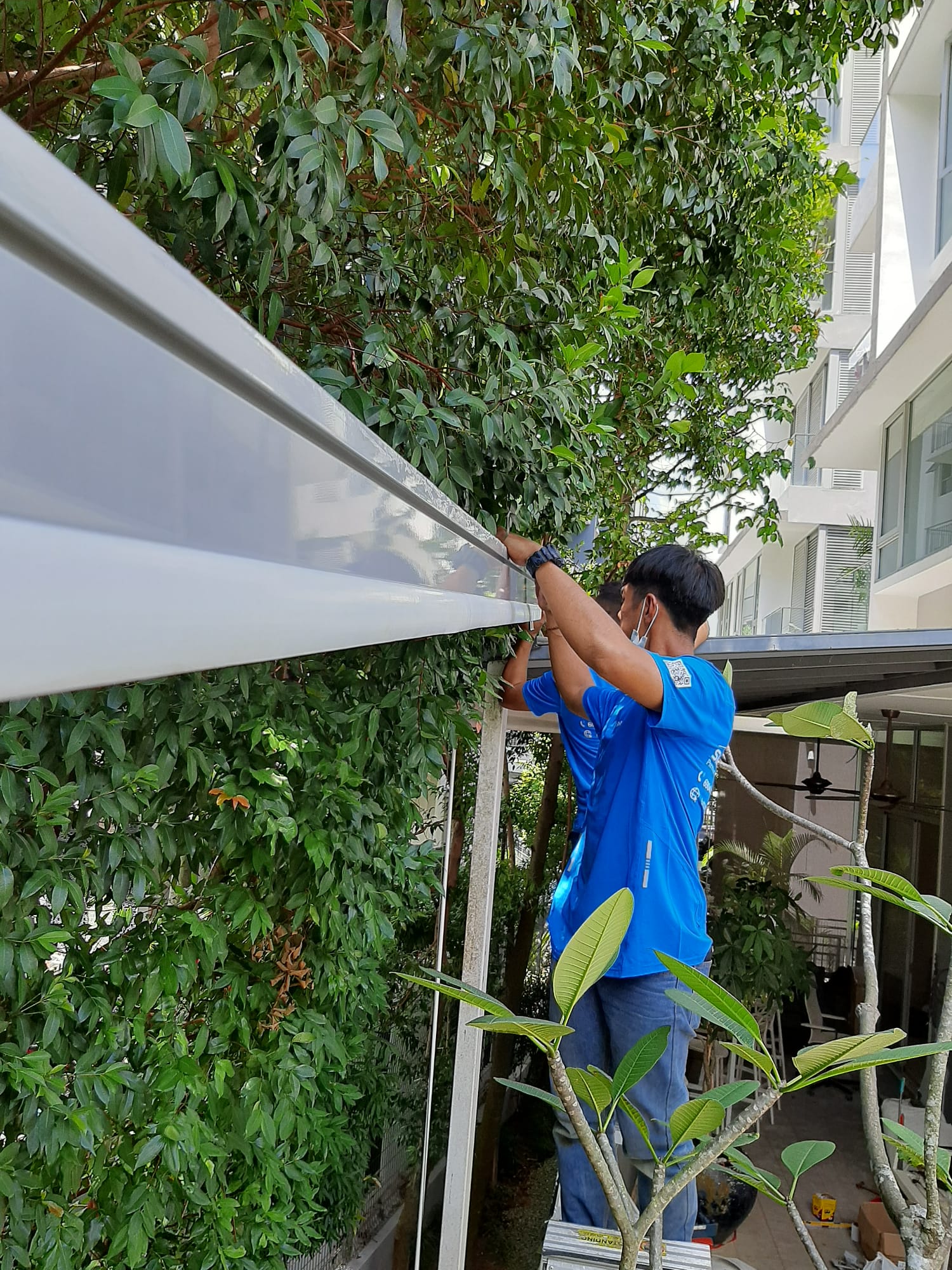 Pergola installation Singapore technician aligning an outdoor roof component
