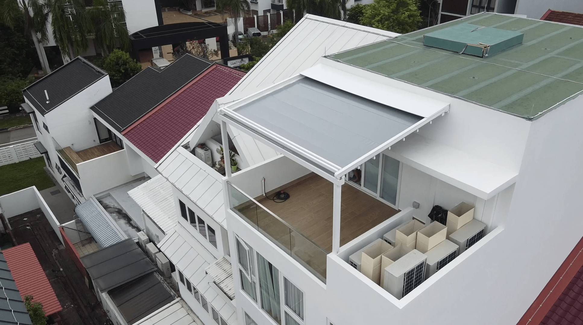 Large rooftop pergola viewed from above beside a residential property