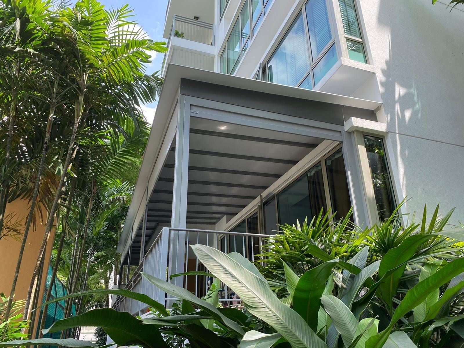 Trellis-style fixed roof covering a narrow exterior area